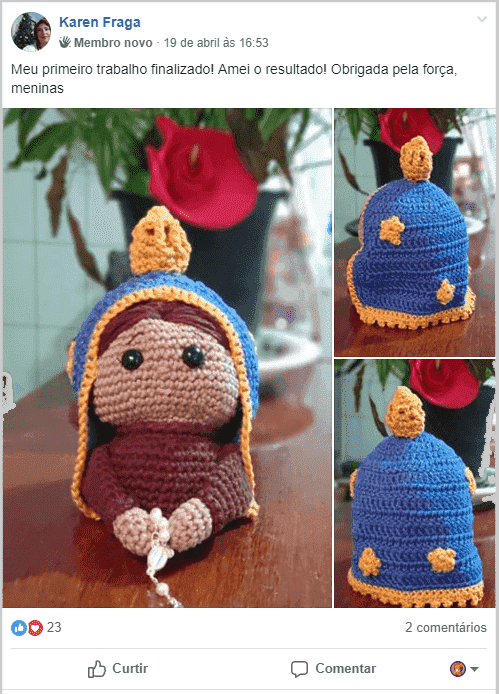 Boneca religiosa em amigurumi feita em crochê, com manto azul e detalhes dourados, segurando um terço.
